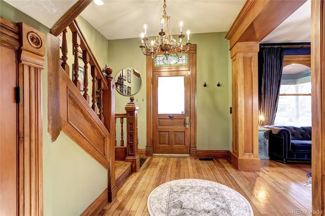 foyer entrance with a chandelier and light wood-type flooring