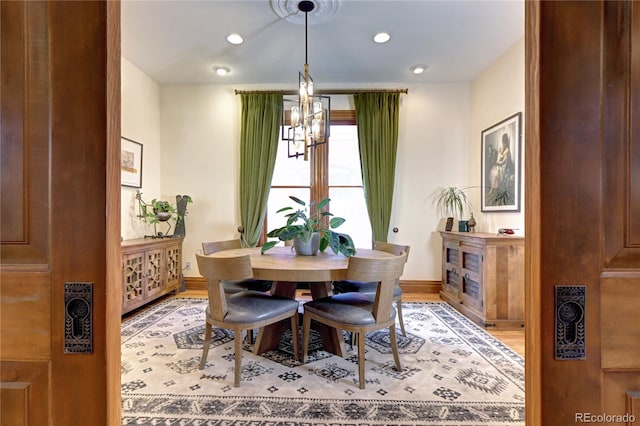 dining area with hardwood / wood-style flooring and a notable chandelier