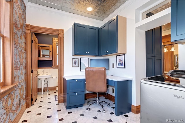 office with crown molding, built in desk, and washer / dryer