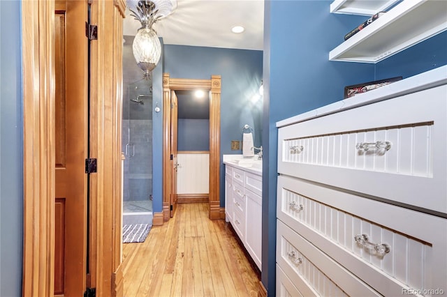 bathroom featuring hardwood / wood-style flooring, vanity, and walk in shower