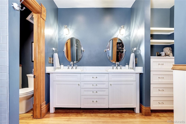 bathroom featuring hardwood / wood-style floors, vanity, toilet, and built in shelves