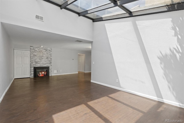 2366 S Troy St, Aurora, CO 80014 - unfurnished living room with wood finished floors, a skylight, a high ceiling, and a fireplace