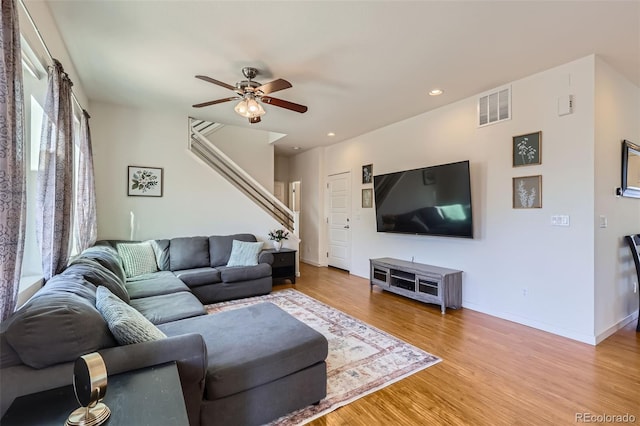 living room featuring a ceiling fan, baseboards, visible vents, recessed lighting, and light wood-type flooring