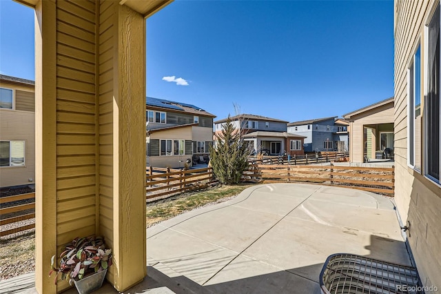 view of patio / terrace featuring fence and a residential view