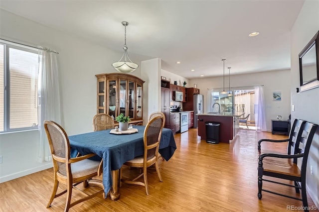 dining room with recessed lighting, light wood-type flooring, and baseboards