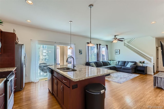 kitchen with a sink, light wood-type flooring, appliances with stainless steel finishes, and recessed lighting