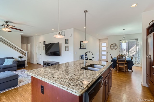 kitchen featuring open floor plan, dishwasher, light wood-type flooring, recessed lighting, and a sink