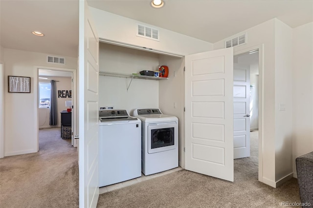 clothes washing area with light carpet, visible vents, laundry area, and washer and clothes dryer