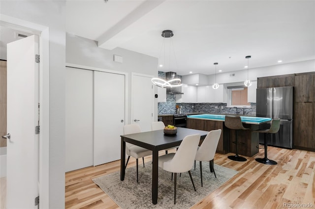 dining area with an inviting chandelier and light wood-style floors