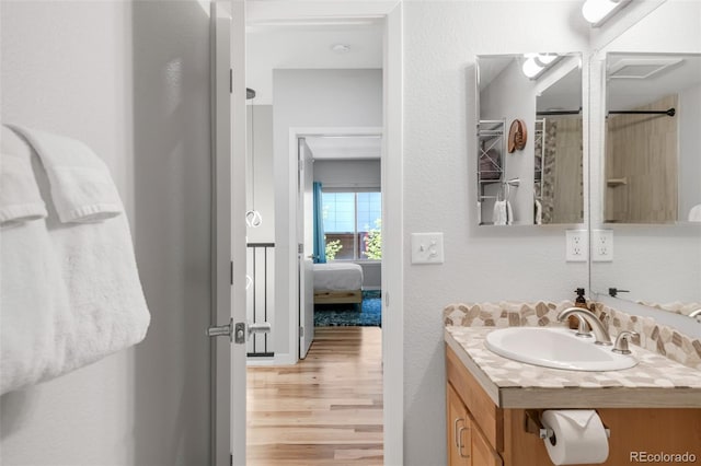 full bath featuring vanity, ensuite bath, and wood finished floors