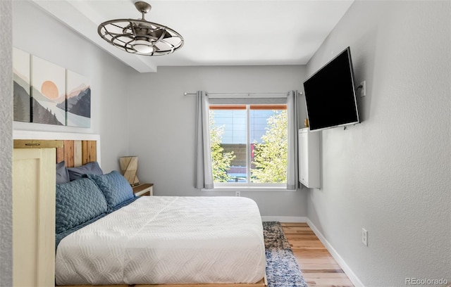 bedroom featuring baseboards and wood finished floors