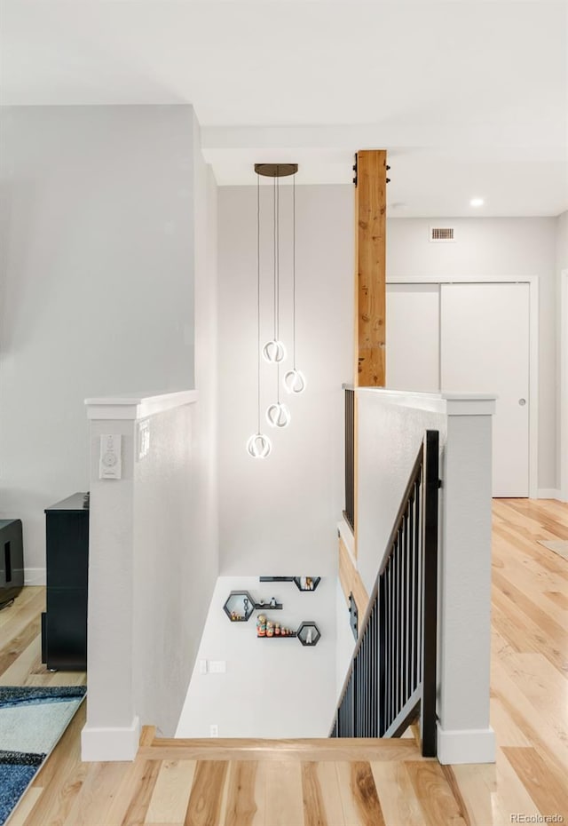 stairs with recessed lighting, baseboards, visible vents, and wood finished floors