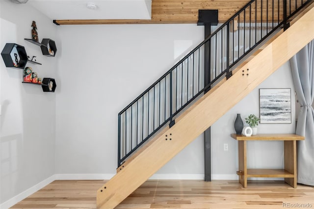 staircase featuring baseboards and wood finished floors
