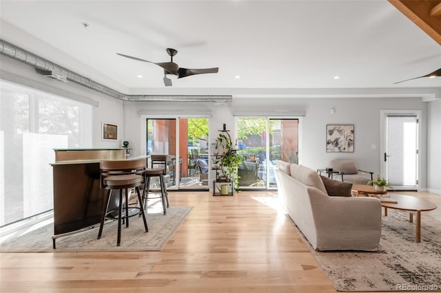 living area with light wood-type flooring, a ceiling fan, and recessed lighting