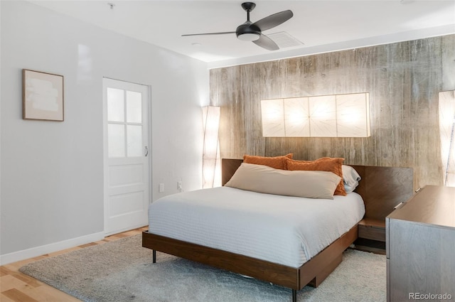 bedroom with baseboards, a ceiling fan, and wood finished floors