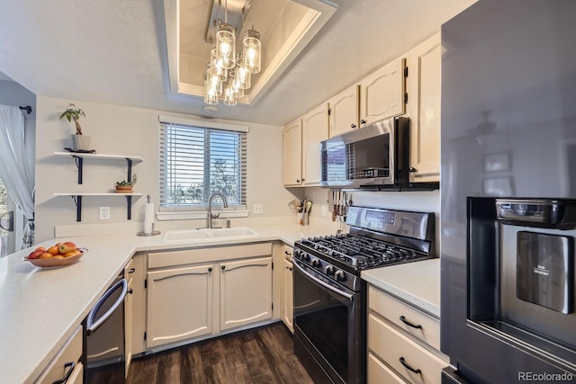 kitchen featuring white cabinetry, sink, a raised ceiling, and gas stove