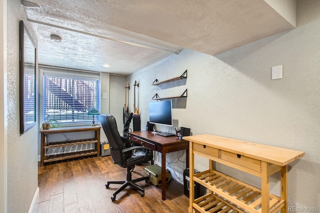 home office featuring hardwood / wood-style floors and a textured ceiling