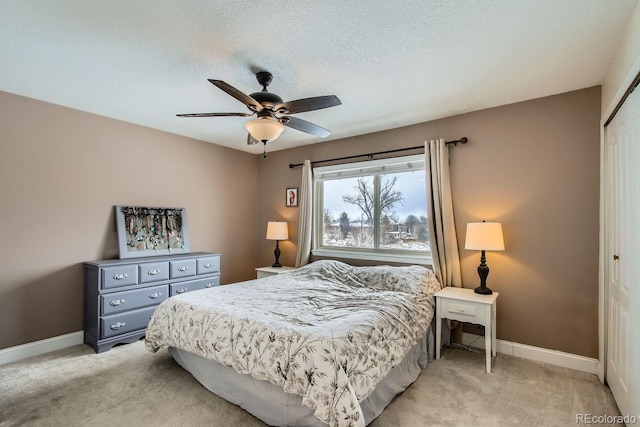 carpeted bedroom with a textured ceiling, a closet, and ceiling fan