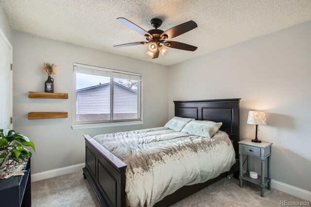 bedroom featuring light carpet, a textured ceiling, and ceiling fan