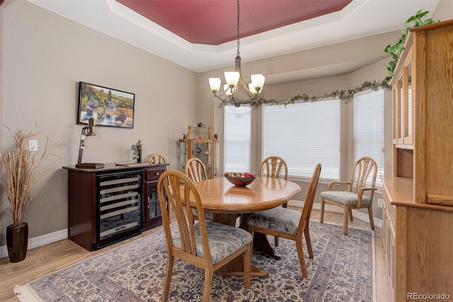 14879 Xenia St, Thornton, CO 80602 - dining room featuring wine cooler, a raised ceiling, a chandelier, baseboards, and healthy amount of natural light