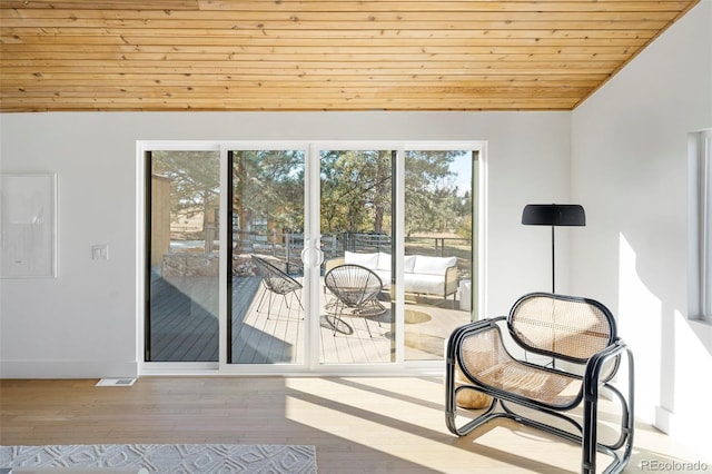 doorway to outside featuring wooden ceiling and light hardwood / wood-style floors