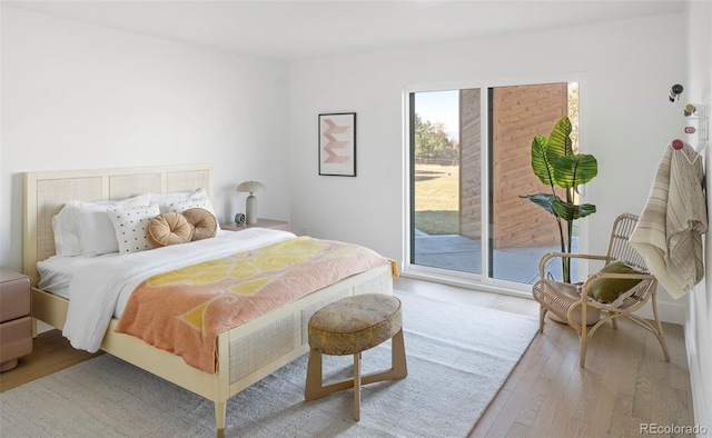 bedroom with access to exterior and wood-type flooring