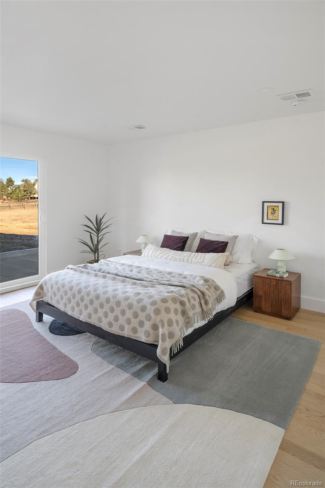 bedroom with access to outside and light hardwood / wood-style flooring