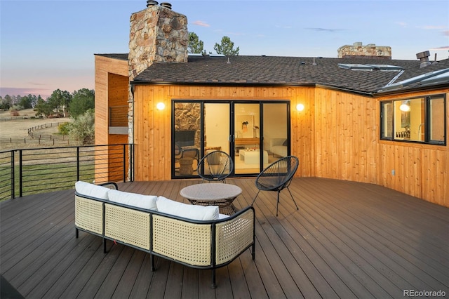 deck at dusk with an outdoor hangout area