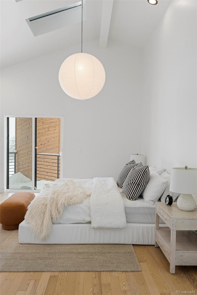 bedroom with hardwood / wood-style flooring and vaulted ceiling with beams