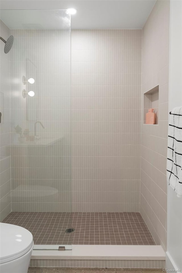 bathroom featuring toilet and tiled shower