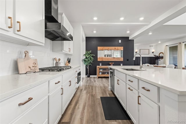 17121 Desert Wine Ln, Parker, CO 80134 - kitchen featuring a sink, wall chimney exhaust hood, tasteful backsplash, white cabinets, and light wood-style flooring