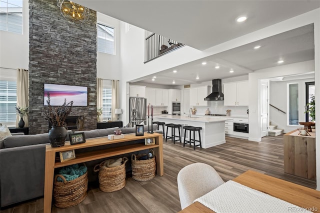 17121 Desert Wine Ln, Parker, CO 80134 - living area featuring stairway, a fireplace, wood finished floors, a high ceiling, and recessed lighting