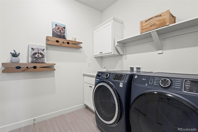 17121 Desert Wine Ln, Parker, CO 80134 - laundry room with washing machine and dryer, cabinet space, baseboards, and light wood-type flooring