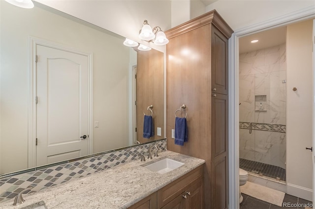 bathroom with vanity, toilet, a notable chandelier, and a tile shower