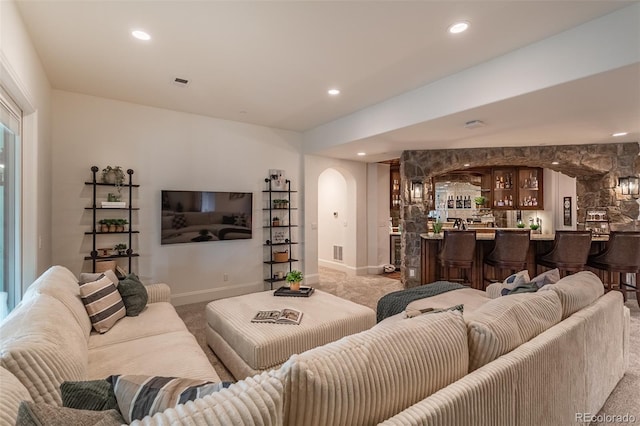 living room with bar area and light carpet