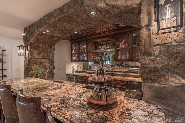 bar with sink and dark brown cabinetry