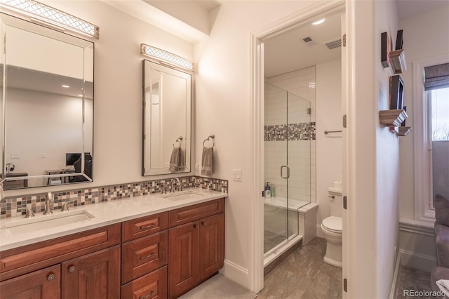 bathroom featuring vanity, toilet, walk in shower, and decorative backsplash