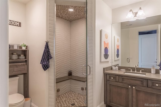 bathroom with a shower with door, toilet, and vanity