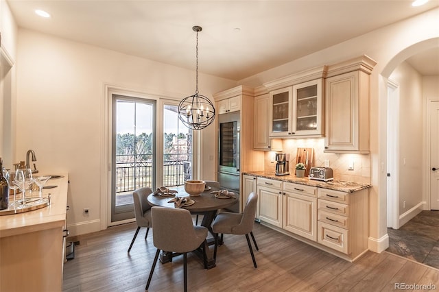 dining space with dark wood-type flooring, sink, and a chandelier