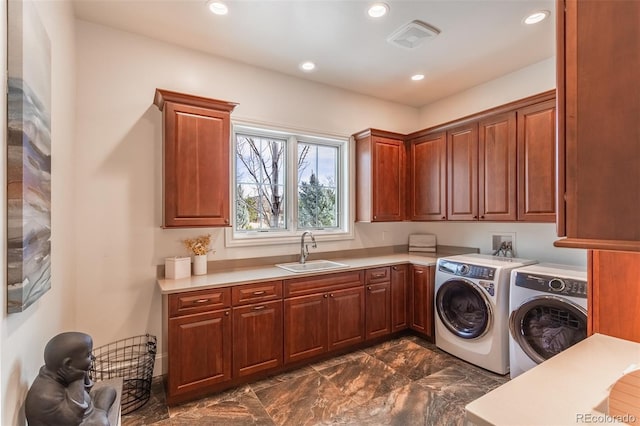 washroom featuring cabinets, sink, and washing machine and clothes dryer