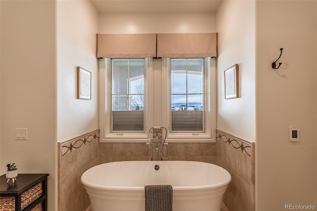 bathroom with a bathtub and tile walls