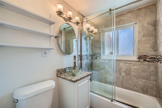 bathroom with toilet, enclosed tub / shower combo, and a sink