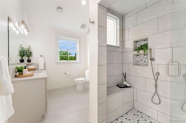 13483 Alcott Way, Broomfield, CO 80020 - bathroom featuring vanity, a tile shower, toilet, baseboards, and tile patterned flooring
