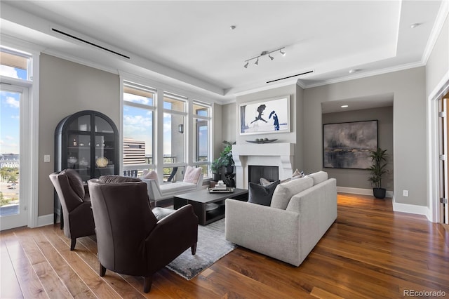 living room featuring plenty of natural light, ornamental molding, and dark wood-type flooring