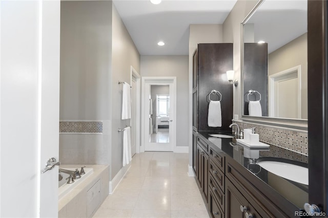 bathroom with tile patterned floors, vanity, and tiled tub