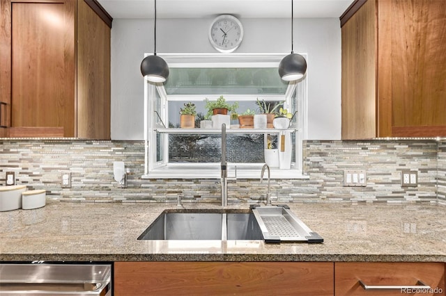 kitchen featuring sink, tasteful backsplash, hanging light fixtures, and light stone countertops