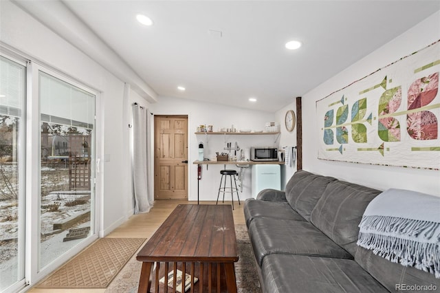 living room featuring light wood-type flooring and lofted ceiling