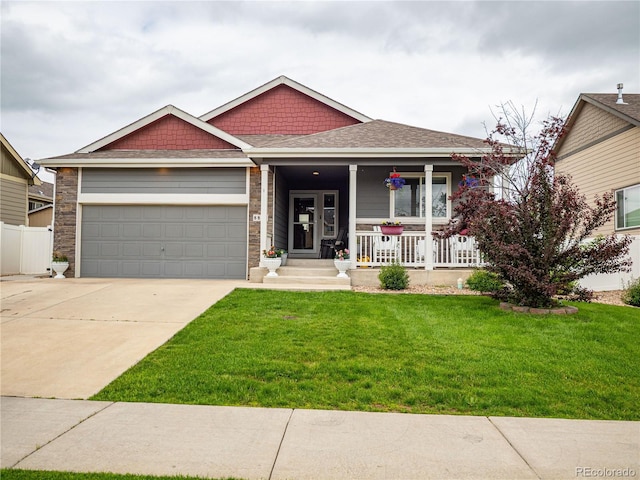8809 15th Street Rd, Greeley, CO 80634 - view of front of property featuring a porch, concrete driveway, a garage, and a front lawn