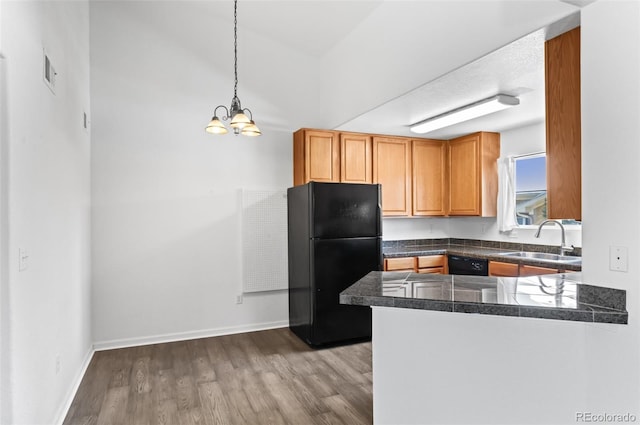 kitchen featuring black appliances, sink, decorative light fixtures, light hardwood / wood-style flooring, and kitchen peninsula