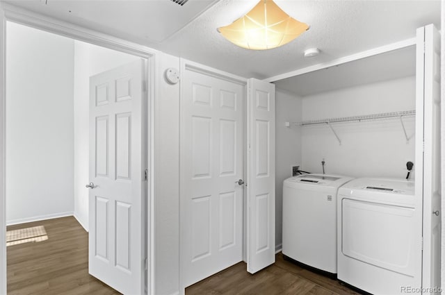 laundry area featuring separate washer and dryer, a textured ceiling, and dark hardwood / wood-style flooring